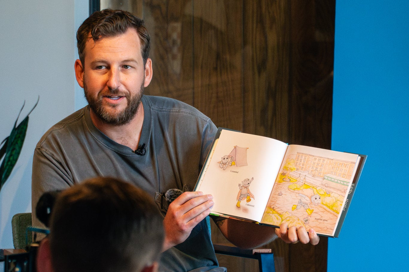 Man reading a book to children in a casual setting